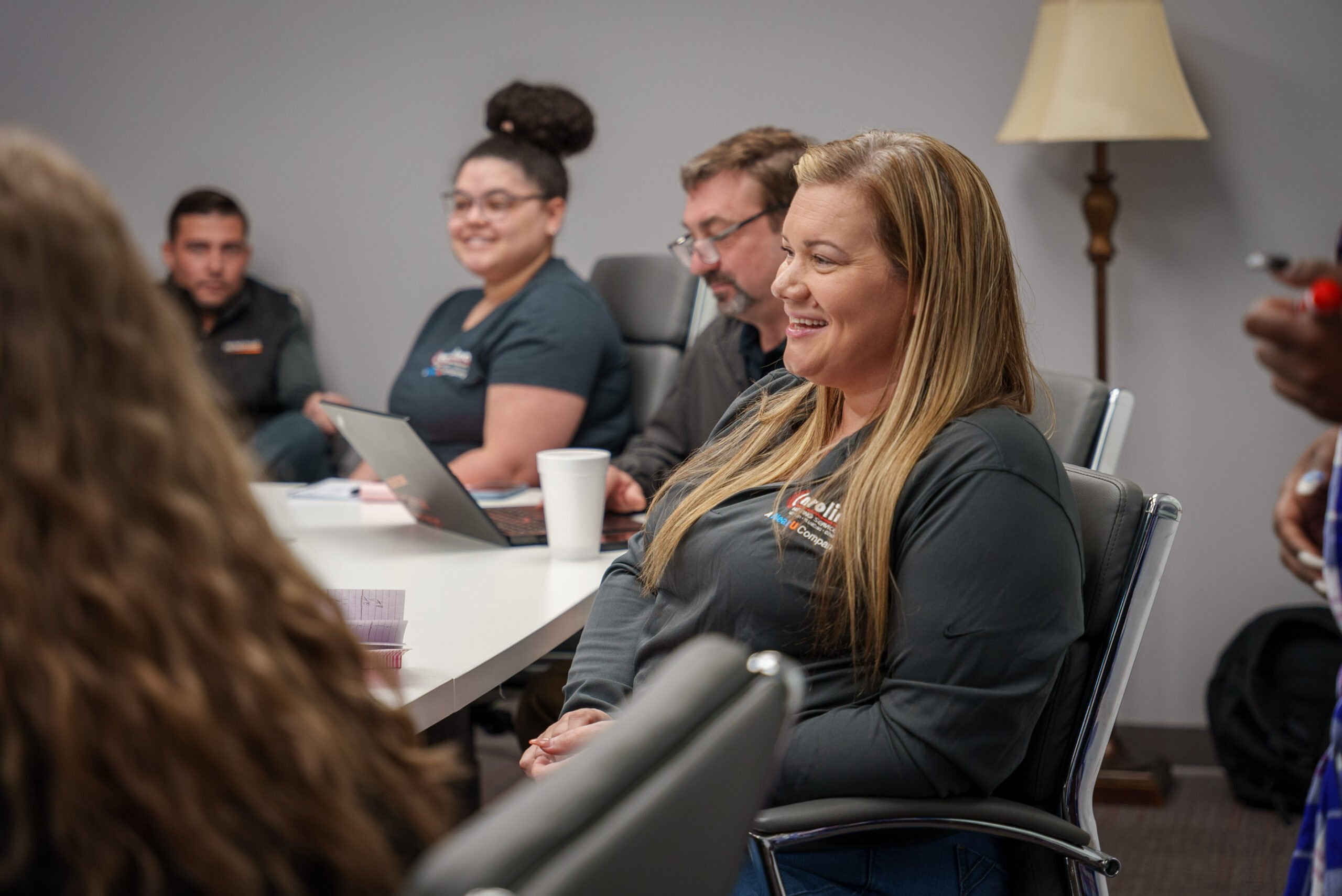 Employees smiling and sitting around a table